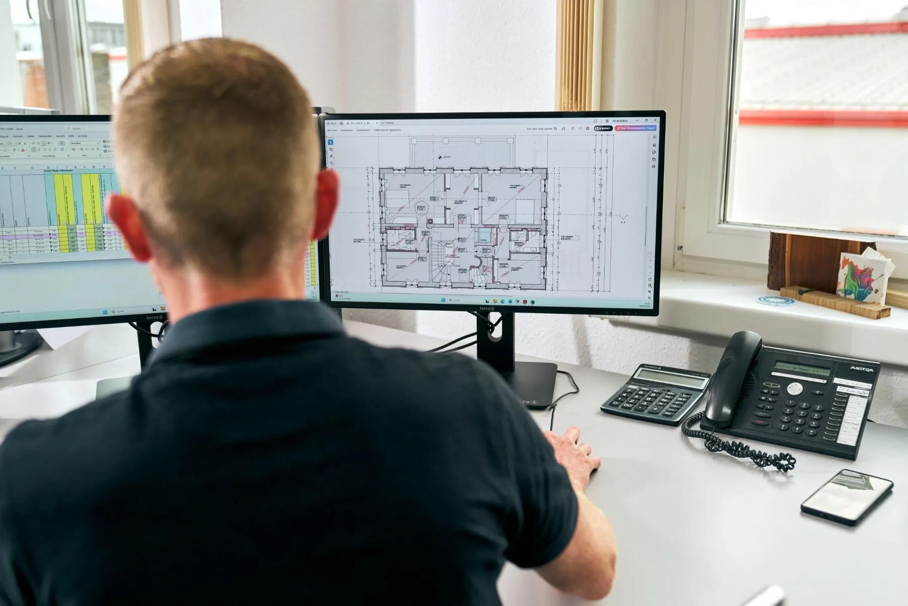 Mitarbeiter der Bauabteilung bei der Arbeit an Plänen am Bildschirm