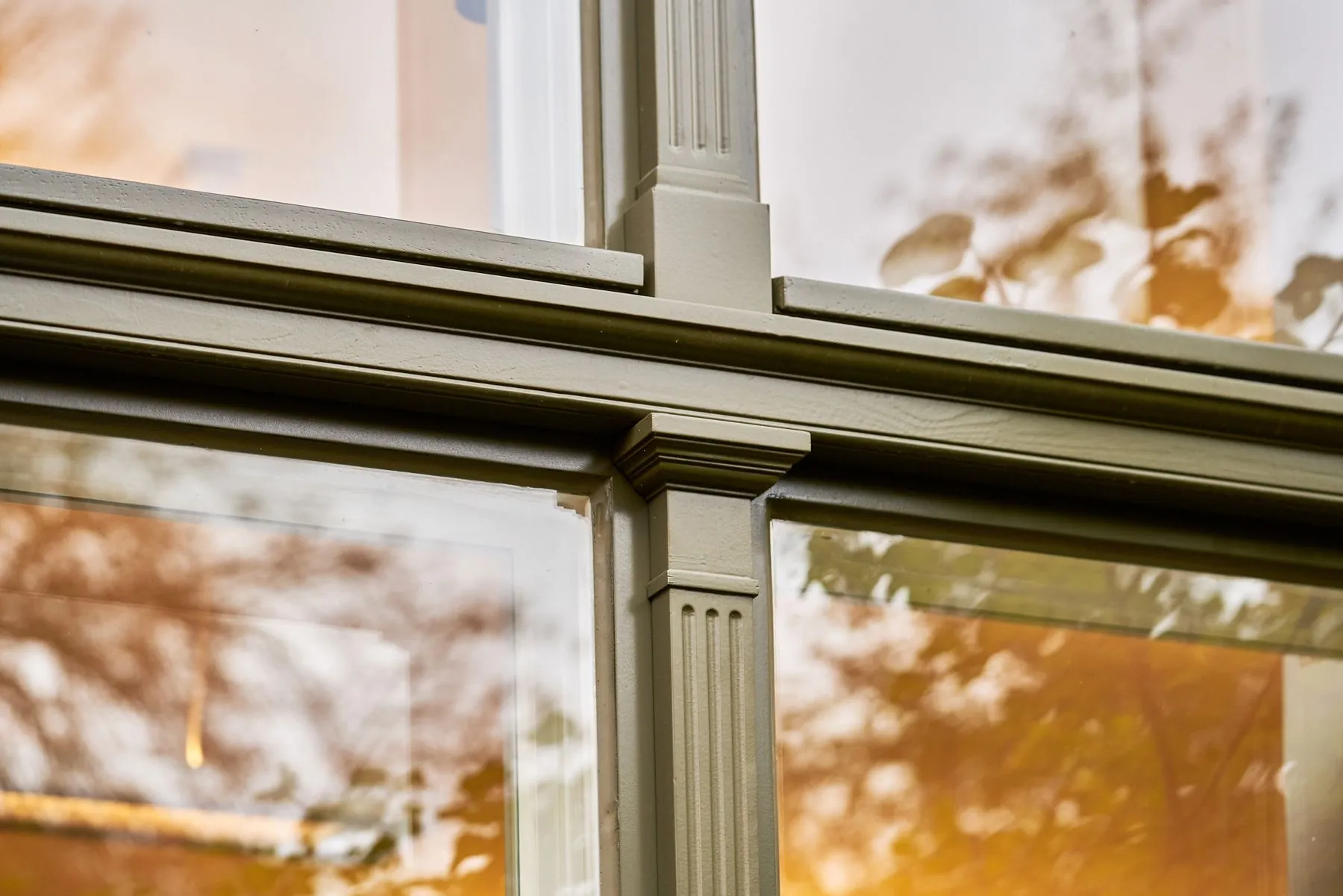 Detail eines denkmalgerecht restaurierten Holzfensters mit kannelierter Pfoste